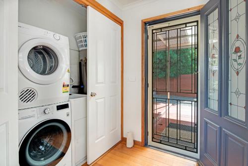 a laundry room with a washer and dryer next to a door at Bay of Fires Great Escape in Binalong Bay