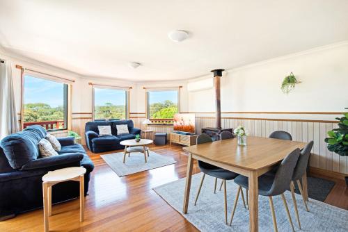 a living room with a blue couch and a table at Bay of Fires Great Escape in Binalong Bay