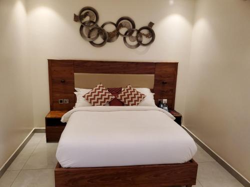 a bedroom with a large white bed with red pillows at Millennium Terrace Hotel in Kampala