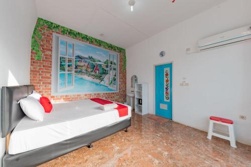 1 dormitorio con cama y pared de ladrillo en RedDoorz Resort Syariah @ Jaya Tirta Abadi, en Purwakarta