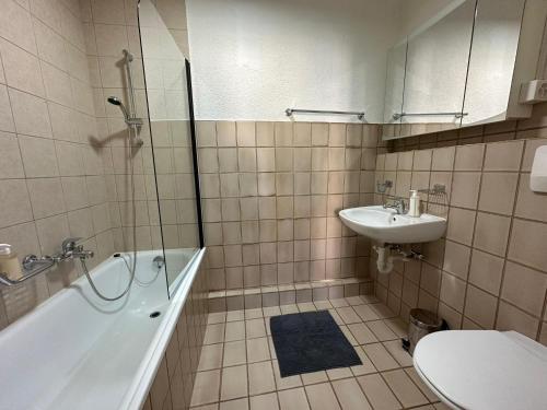 ein Badezimmer mit einer Badewanne, einem Waschbecken und einem WC in der Unterkunft Sion Central Station proche toutes commodites in Sion