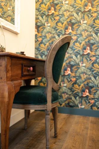 a wooden desk with a green chair next to a desk at Les Granges de Jules in Lafitte-Vigordanne