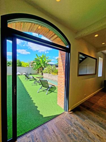 a room with a large window with a view of a patio at Les Granges de Jules in Lafitte-Vigordanne