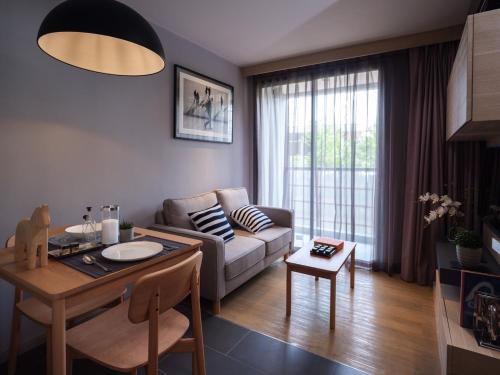 a living room with a couch and a table at VOQUE Hotel & Serviced Residence Sukhumvit 51 in Bangkok
