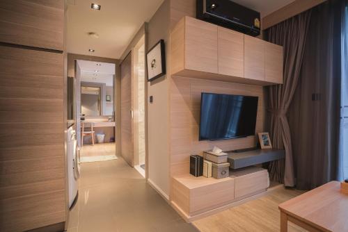 a living room with a flat screen tv on a wall at VOQUE Hotel & Serviced Residence Sukhumvit 51 in Bangkok