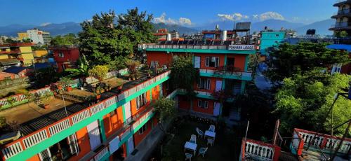 a city with colorful buildings and mountains in the background at New Pokhara Lodge - Pokhara Lakeside in Pokhara