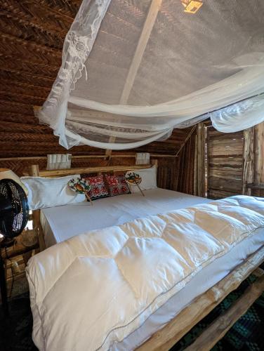 a bedroom with a white bed with a canopy at Mawe Mawili in Tanga