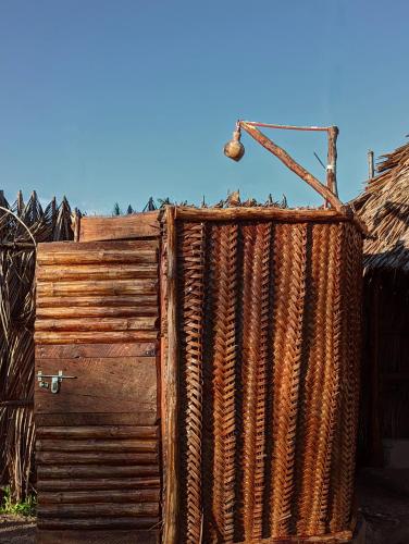 a wooden fence with a large coil of hose at Mawe Mawili in Tanga