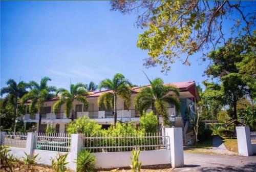 a house with a white fence in front of it at Langkawi Rouhi Retreats By VP in Kuah