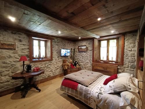 a bedroom with a bed and a table and windows at La montagnarde des Sapins Blancs in Vacheresse