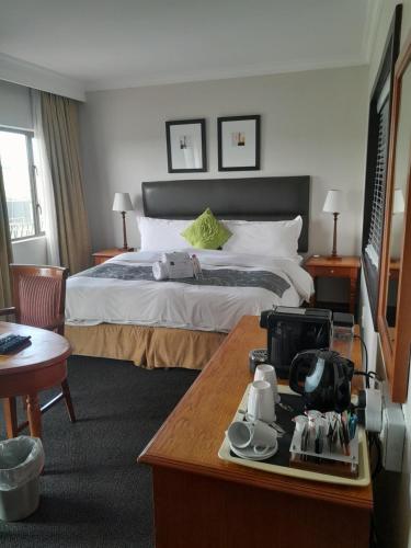 ein Hotelzimmer mit einem Bett und einem Tisch in der Unterkunft Protea Hotel by Marriott Harrismith Montrose in Harrismith