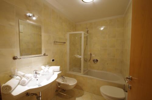 a bathroom with a sink and a shower and a toilet at Villa Hubertus in Ortisei