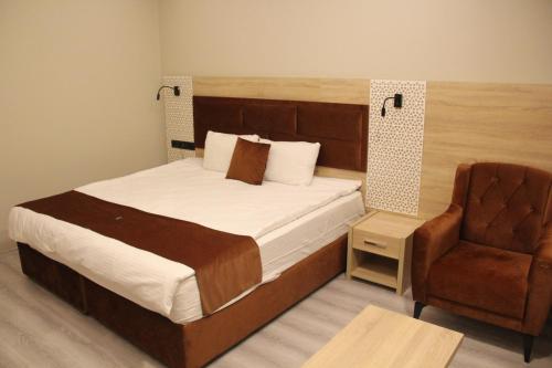 una camera con un grande letto e una sedia di Arhavi Resort Otel ad Arhavi