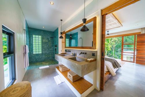 uma casa de banho com um lavatório e um espelho em KClub River Front 4 - Majestic & Luxurious 5BR Villa In Pererenan em Canggu