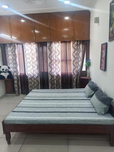 ein großes Bett in einem Zimmer mit Vorhängen in der Unterkunft Chandigarh home in Chandīgarh