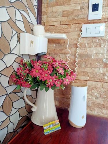 a vase with flowers in it sitting on a table at ภูฝ้ายวิลล่า Phufai villa in Chiang Khan