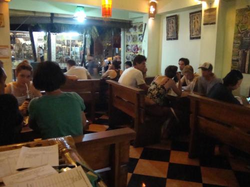 a group of people sitting in a restaurant at Gusti Home Stay Ubud in Ubud