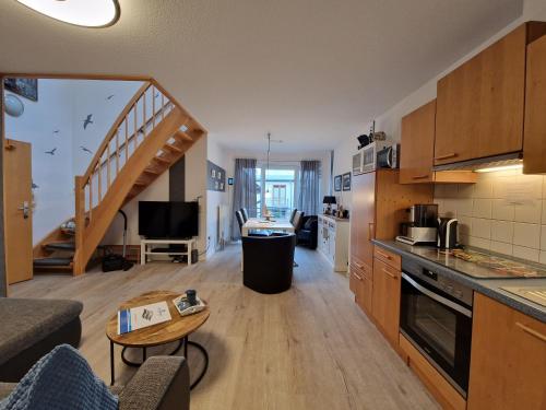 a living room with a kitchen and a stairway at Haus Seewind Wohnung 3 in Cuxhaven