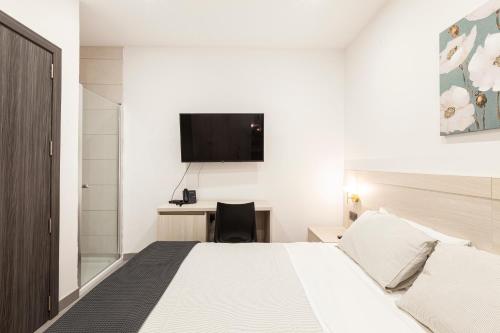 a bedroom with a bed and a desk with a television at Guesthouse No. 48 in Msida