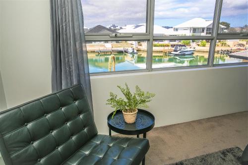 a room with a couch and a table and a window at CHILLAX HOUSE - Luxury, Canals, Jetty, Family Friendly - Sleeps 14 in Style! in Mandurah