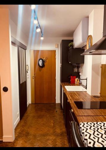 une cuisine avec un comptoir et une porte marron dans l'établissement CŒUR de DEAUVILLE 3 mn plage 3 mn casino Charme absolu, à Deauville