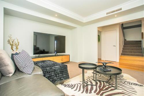 a living room with a couch and two tables at CHILLAX HOUSE - Luxury, Canals, Jetty, Family Friendly - Sleeps 14 in Style! in Mandurah