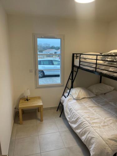 1 dormitorio con litera y mesa en St Jean de Monts Maison neuve 15 pers 6ch en La Parée Preneau