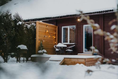 una cabaña en la nieve con mesa y sillas en Alejas apartamenti en Augšlīgatne