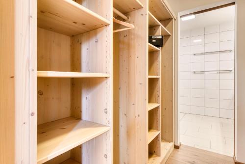 a walk in shower room with wooden shelves at Appartements im Kirchberg by A-Appartments in Fontanella