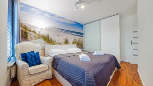 グダニスクにあるApartamenty Sun&Snow Marina Primoreのベッドルーム1室(ベッド1台、椅子付)