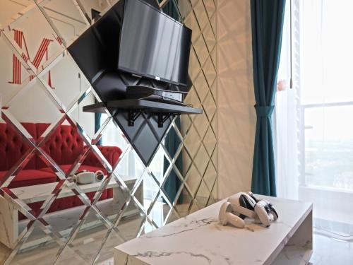 a living room with a tv and a table at MORITZ INN BSD TANGERANG in Tangerang