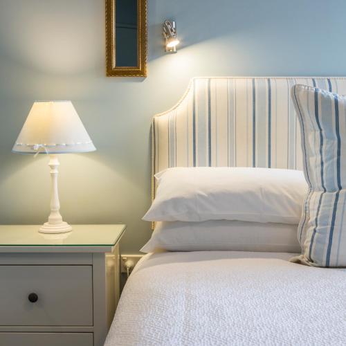 a bedroom with a bed with a lamp on a night stand at The Beach House At Bayside in Albany