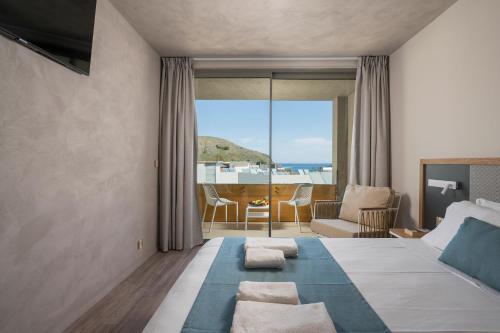 1 dormitorio con 1 cama y vistas al océano en Corissia Beach hotel en Georgioupolis