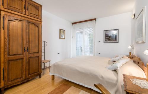 ein Schlafzimmer mit einem großen Bett und einem Holzschrank in der Unterkunft Apartments Sonja in Opatija