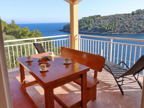 stół i krzesła na balkonie z widokiem na ocean w obiekcie Peaceful Holiday House Senija w mieście Vela Luka