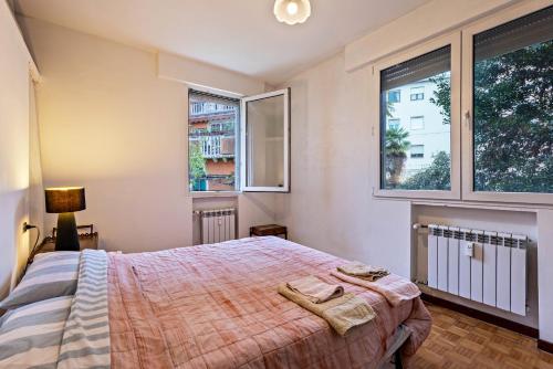 een slaapkamer met een bed en 2 ramen bij Via Mocenigo in Venetië-Lido