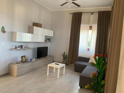 uma sala de estar com um sofá e uma televisão em PRAIOLA BEACH HOUSE em Pozzillo