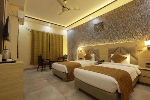 a hotel room with two beds and a table at THE BODHI PALACE RESORT in Bodh Gaya