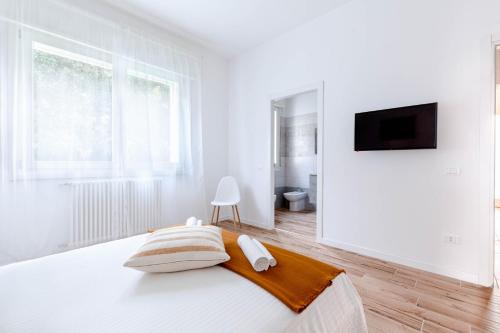 una camera bianca con letto e TV a schermo piatto di Villetta Padova a Padova