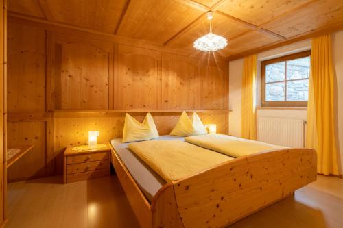 a bedroom with a bed in a wooden room at Grossgasteigerhof in Selva dei Molini