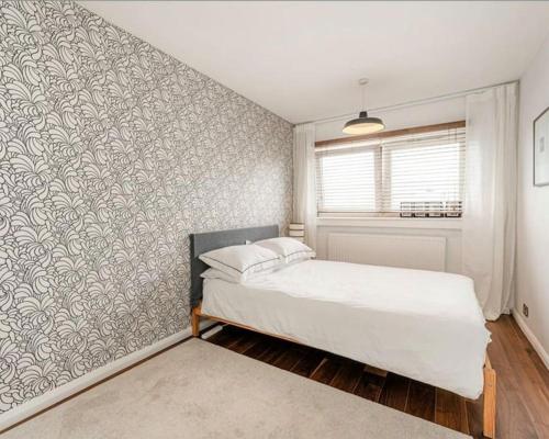 een slaapkamer met een bed en een muur bij Platform 9 3/4 by condokeeper in Londen