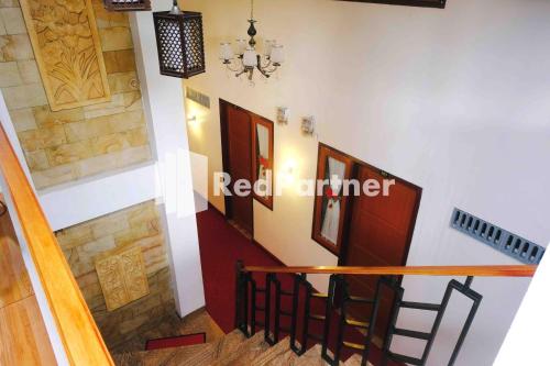 a staircase with a red stairiner sign on the wall at Guest House Bibong Makassar Mitra RedDoorz in Makassar