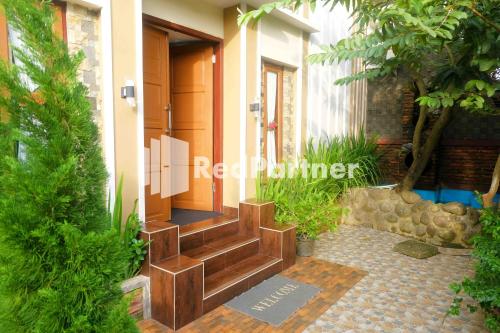 a entrance to a building with a wooden door at Guest House Bibong Makassar Mitra RedDoorz in Makassar