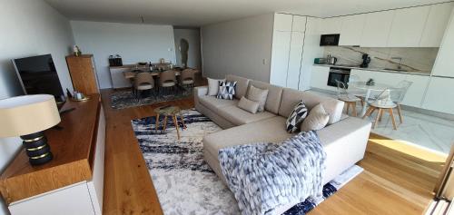 uma sala de estar com um sofá e uma cozinha em The View - Porto - Apartment on TOP location with amazing view! em Vila Nova de Gaia