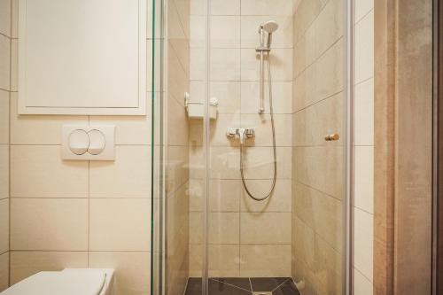 uma casa de banho com uma cabina de duche em vidro e um WC. em Central Apartment Budapest ~ Roof Terrace/AC/Indoor parking em Budapeste