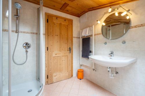 a bathroom with a sink and a shower and a mirror at Grossgasteigerhof in Selva dei Molini