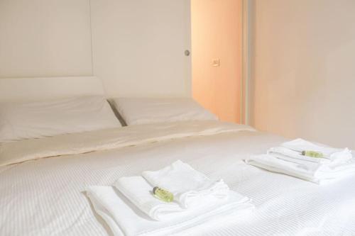 a white bed with towels on top of it at Erbe Canal View Private House in Venice