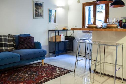 a living room with a blue couch and a kitchen at Erbe Canal View Private House in Venice