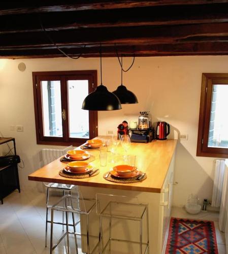 a kitchen with a table with plates and wine glasses at Erbe Canal View Private House in Venice