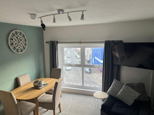 sala de estar con mesa y ventana en Topzy-Turvy - 1 Bedroom Apartment en Swansea